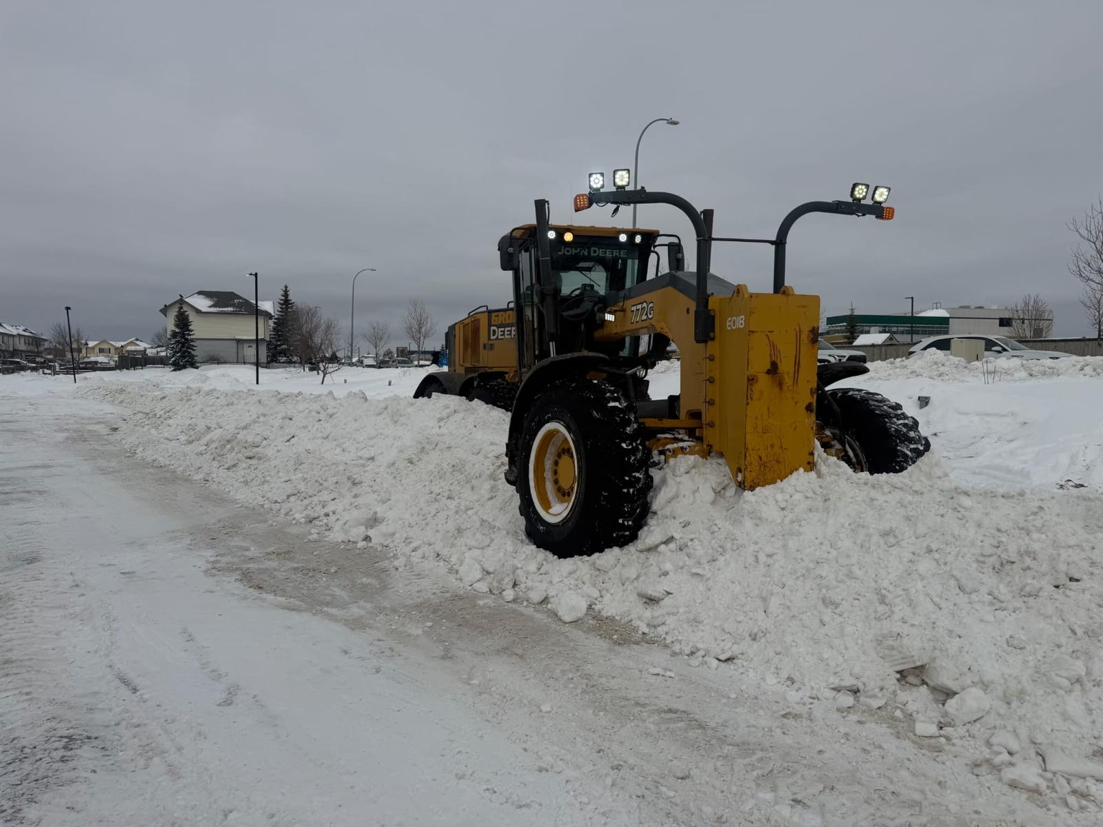 Snow removal grader clearing roads in Fort McMurray